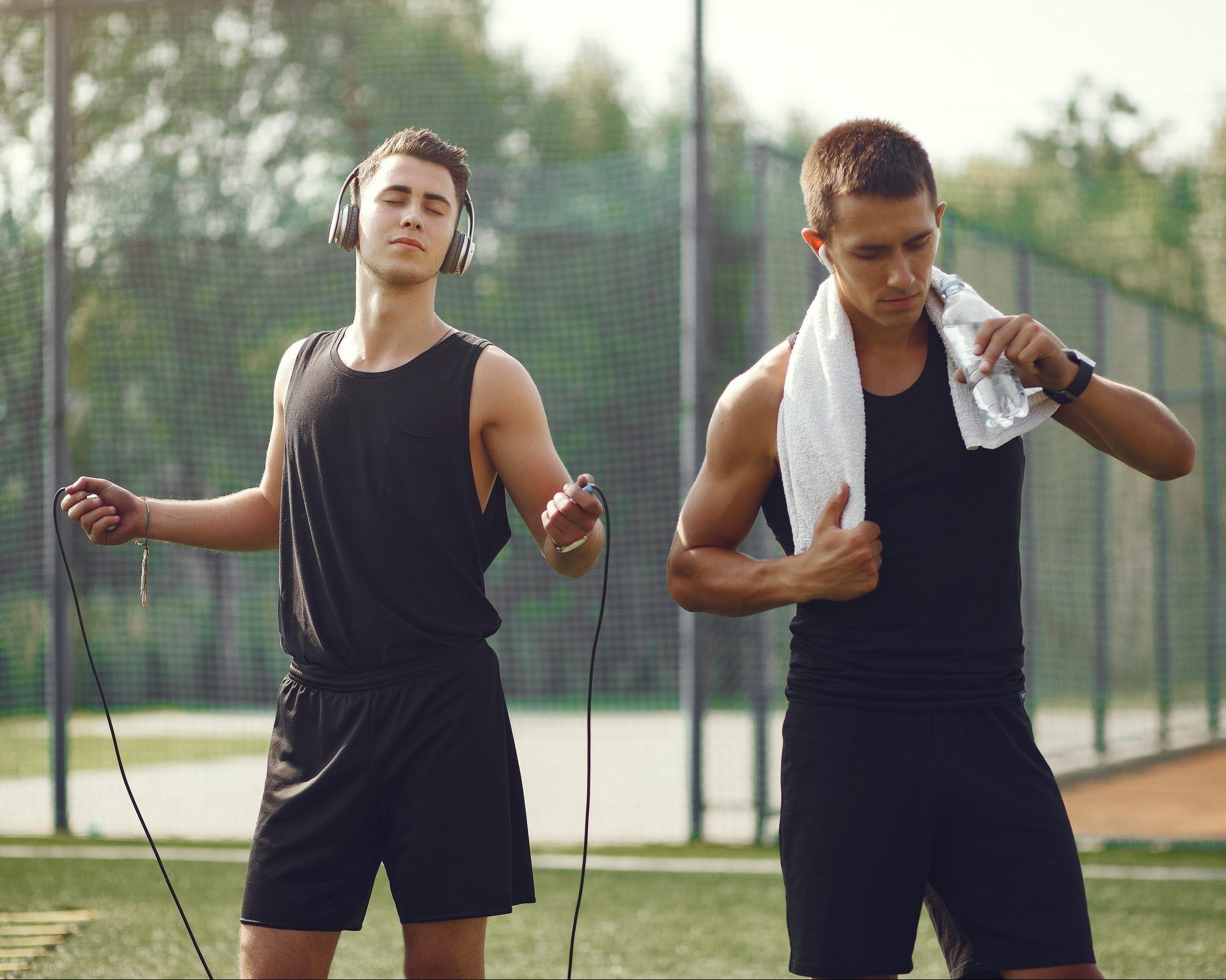Men in a city. Guys in a sports clothes. Male drinking a water